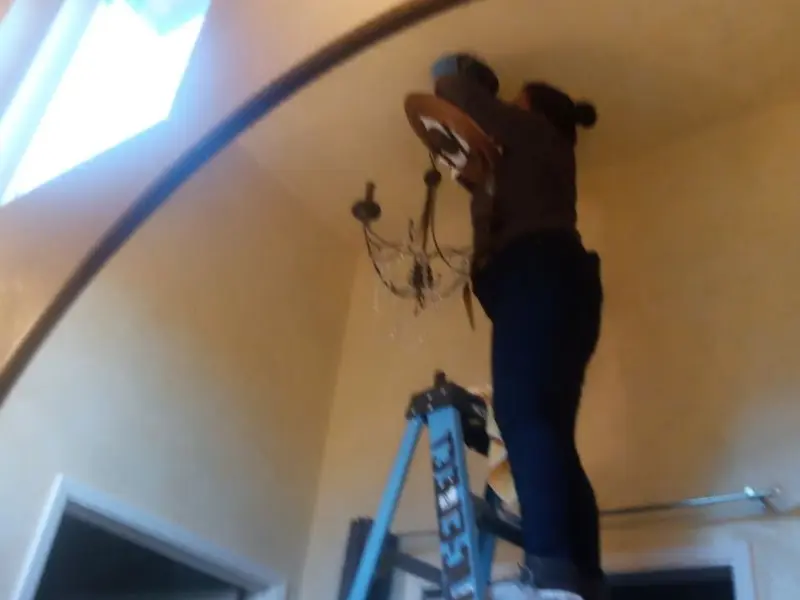 Electrician installing a chandelier in a Bainbridge residence